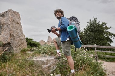 seyahat ve fotoğraf konsepti, mutlu Hintli sırt çantalı dijital kamera kullanan doğa gezisi