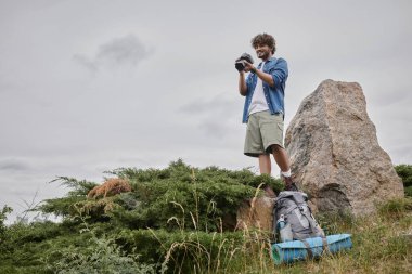 fotoğraf ve doğa konsepti, Hintli turist dijital kamerada çekim yapıyor ve rock 'ın üzerinde duruyor.