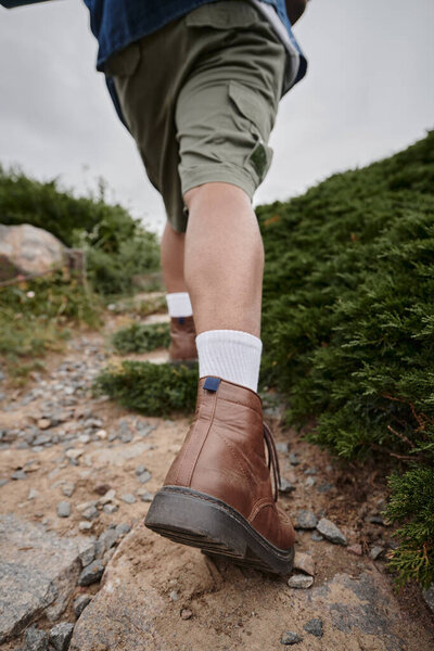 tranquil nature, cropped view of hiker walking in brown boots with white socks, adventure, traveler
