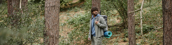 индийский турист с вьющимися волосами ходьба в лесу, естественное местоположение, турист с рюкзаком, баннер