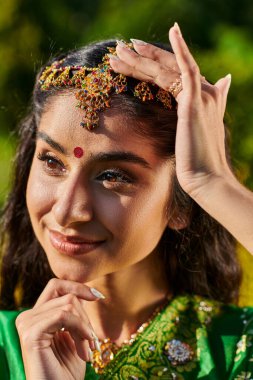 Bindi ve Matha Patti 'nin açık havada durduğu şık ve neşeli Hintli kadın portresi