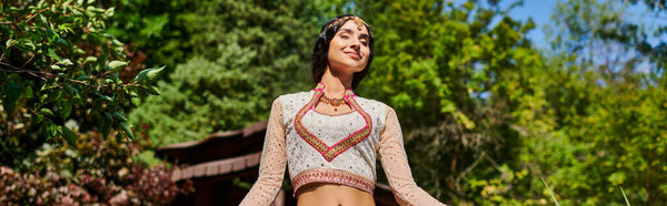 summer park outing, indian woman in traditional wear smiling with closed eyes, enjoyment