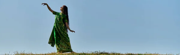 年轻的印度女人 穿着传统的莎丽服 在蓝天下的绿地里 — 图库照片