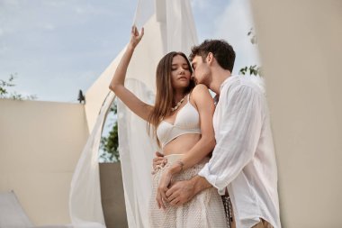 Seksi çift, dövmeli ve omzunu öpen çekici kadını baştan çıkaran erkek, dışarıda dikilen.