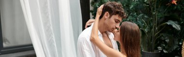 Seksi çift, tutkulu adam tatilde güzel bir kadına sarılıyor. Öpüşmeden önce, pankartta.