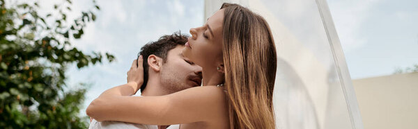 sexy couple, man kissing neck of woman while standing near white tulle of pavilion on beach, banner