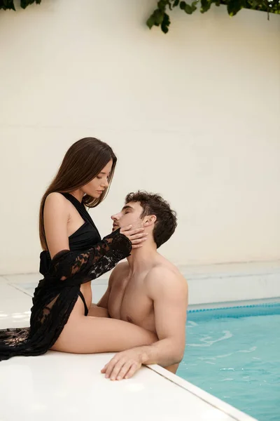 性感的一对 穿着泳衣和黑色海滩的女人穿着迷人的赤身裸体男人在游泳池里 — 图库照片