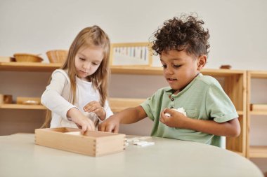 Matematik öğrenme, Afrikalı Amerikalı bir erkek kızla oynuyor, Montessori okulu konsepti, çeşitli çocuklar.
