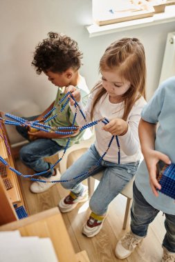 Akıllı kız Montessori inci boncuklarıyla oynuyor. Matematik, ırklar arası çocuklar, çeşitlilik.