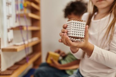 Afrika kökenli Amerikalı erkek, çeşitlilik, Montessori kavramı yanında boncuk taşıyan kırpık bir kız.