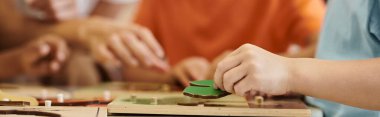 Montessori okulunda öğretmenlerin yanında didactic malzemelerle oynayan çocuklara kısmi bakış açısı, afiş