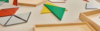 colorful triangles on table in class of montessori school, banner clipart