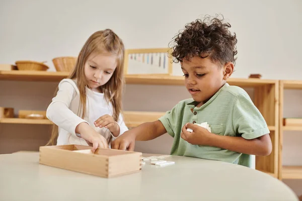 math learning, african american boy playing with girl, montessori school concept, diverse kids