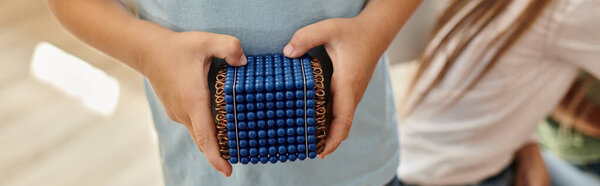 усеченный вид, умный мальчик, держащий в руках свеклу Монтессори, изучает математику, размытый, баннер