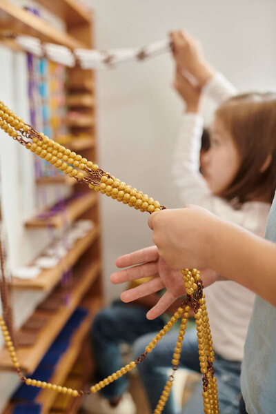 kid counting yellow beads, Montessori school concept, childhood, education, math, curiosity, study