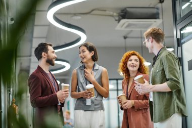 Modern ofiste kahve molası, neşeli iş arkadaşları konuşuyor ve içecek bir şeyler hazırlıyorlar.