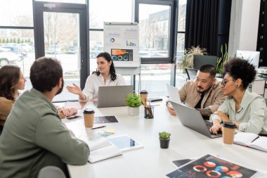 Takım lideri modern ofis ve çeşitlilik toplantılarında ırklar arası iş adamlarıyla konuşuyor.