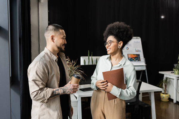 азиатский бизнесмен с чатом кофе с африканской американкой коллегой в офисе, коворкинг