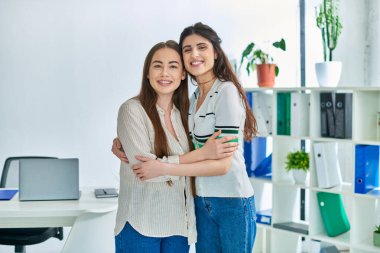 Mutlu lezbiyen çift birbirlerine sarılıyorlar ve kameraya bakıyorlar, tüp bebek konseptiyle.