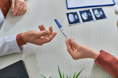 Hastanın pozitif hamilelik testini ultrasonla doktora, lV konseptiyle göstermesine yakın.