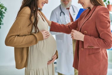 cropped view of doctor standing next to pregnant lesbian woman with her partner, ivf concept clipart