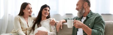 Baba hamile kızı ve partneri gülümsüyor ve çay içiyor, VF konsepti, pankart
