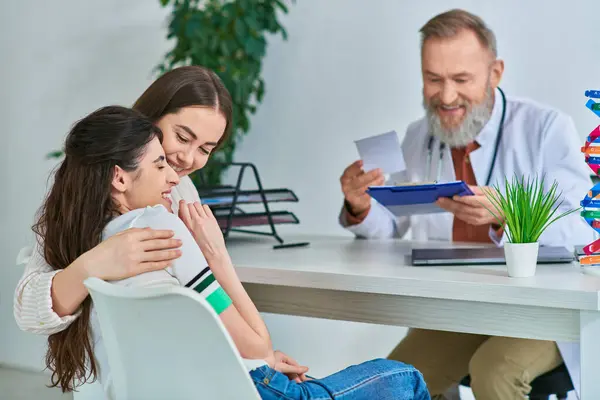 Stock image happy lgbt couple hugging warmly and smiling at gynecologist office, in vitro fertilization concept