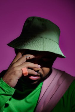 Panama 'da parmağında yüzükler olan yakışıklı bir adamın yüzünü elle kapatması, moda konsepti.