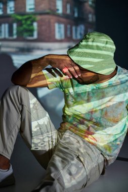 good looking african american male model posing with hand closing his face, fashion concept clipart