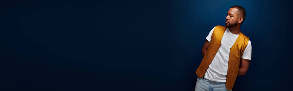молодой красивый мужчина в стильном желтом жилете, позируя из стороны в сторону, концепция моды, баннер