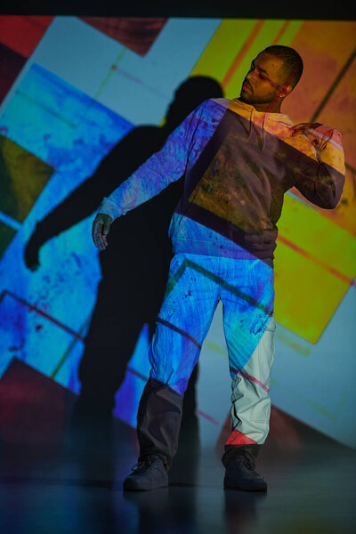 Африканский американец, стоящий и жестикулирующий руками в цифровом проекторе, концепция моды