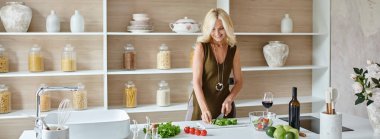 modern kitchen banner, cheerful blonde middle aged woman making salad from fresh ingredients clipart