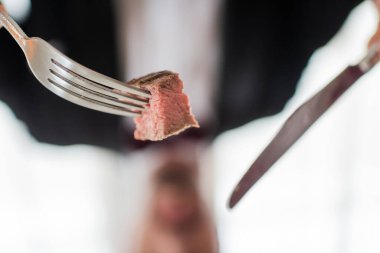 close up shot of medium cooked delicious beef steak and silver knife and fork, gourmet meal clipart