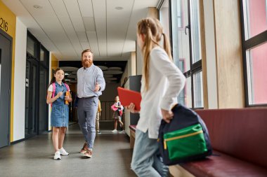 A diverse group of kids walk down a bright hallway, led by their enthusiastic teacher on an educational adventure. clipart