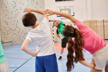 Genç bireylerden oluşan dinamik bir grup basketbol sahasının tepesinde duruyor, spor için birlik ve tutku sergiliyorlar..