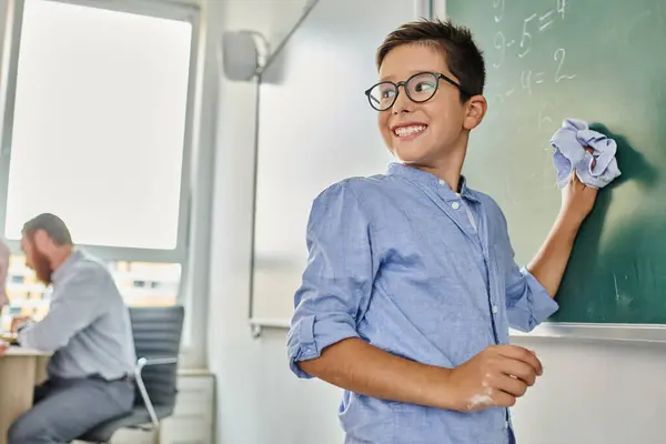 Kid Stands Blackboard Smiling Vibrant Classroom Setting — Stockfoto