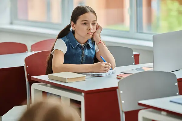 Ein Junges Mädchen Sitzt Einem Schreibtisch Mit Gelangweiltem Gesichtsausdruck Der — Stockfoto
