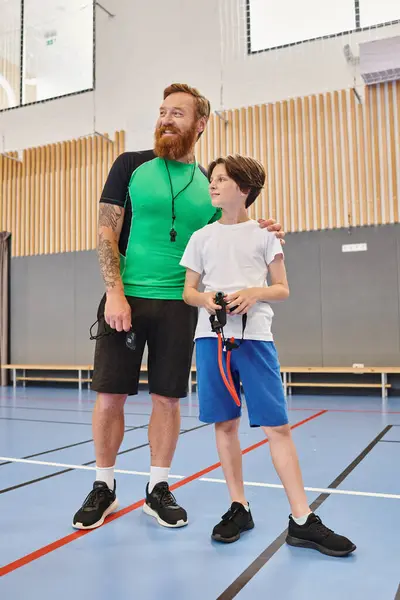这名男子正在篮球场上训导小男孩 以一种支持和吸引人的方式展示游戏的基本内容 — 图库照片