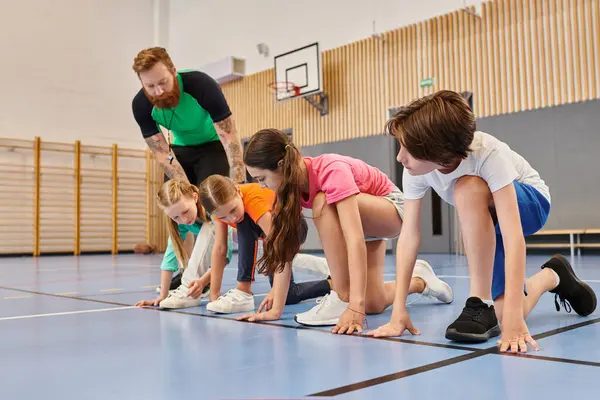 Bir erkek öğretmenin parlak bir sınıf ortamında onlara öğrettiği gibi çeşitli gençler mavi bir katta bir arada duruyorlar..
