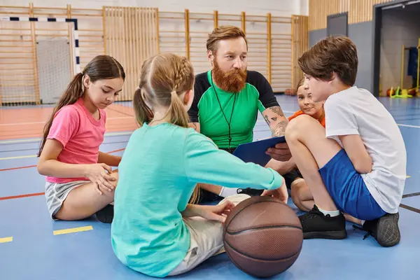 stock image A diverse group of young people enjoying a moment of togetherness on top of a basketball court, immersed in conversation