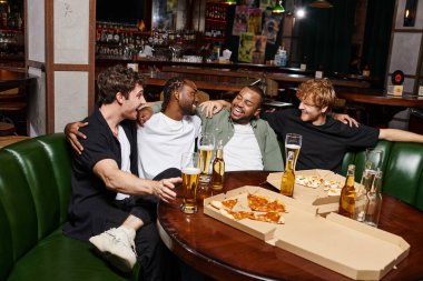 four happy interracial friends hugging and chatting near pizza and beer, spending time in bar clipart