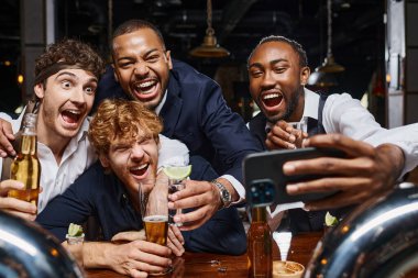 Heyecanlı çok ırklı iş arkadaşları işten sonra barda selfie çekiyorlar.