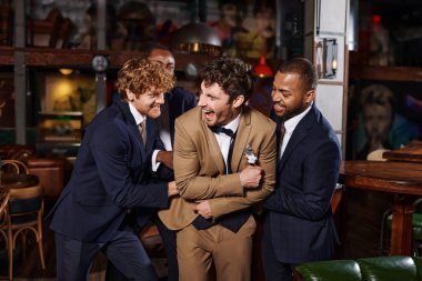 bachelor party, excited interracial men congratulating friend in bar, best men tickling groom clipart