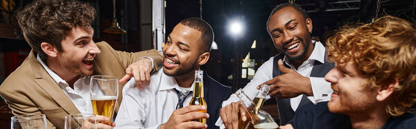banner of interracial colleagues in formal wear toasting beer in bar, men having fun after work