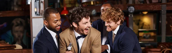 stock image bachelor party banner, excited interracial men congratulating friend in bar, best men tickling groom