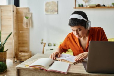 concentrated short haired woman with headphones studying from home looking at textbook, education clipart