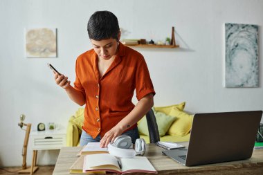 short haired hard working woman checking her studying notes and holding phone in hand, education clipart