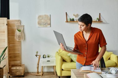 pretty short haired student looking at laptop attentively and checking on her notes, education clipart