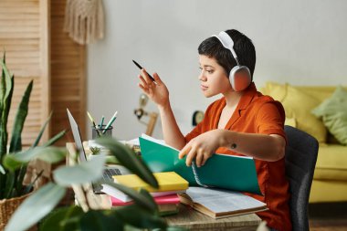 attractive hard working student with short hair and headphones studying hard at home, education clipart