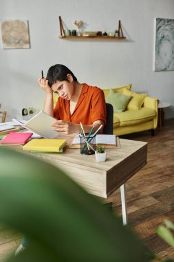 concentrated tired student in casual attire studying hard at home looking at textbook, education clipart